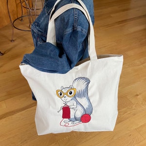 Borsa grande con scoiattolo ricamata. Una tasca interna con cerniera, chiusura con cerniera incassata. Progetti di maglieria. Personalizzazione del colore degli occhiali/filato.