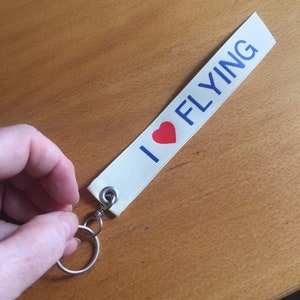 I Love Heart Flying Palm-sized Keyfob. Cream ribbon with blue lettering. airplane/aviation/pilot gift