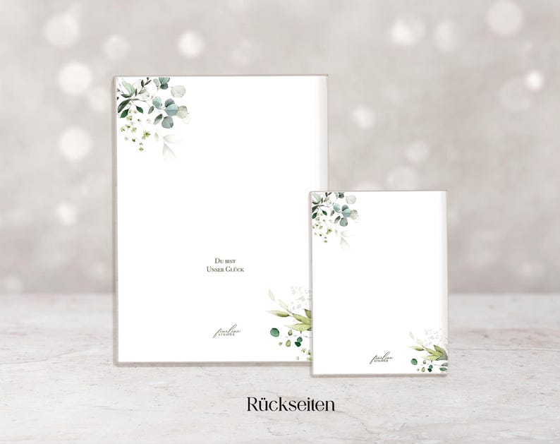 May include: Two white rectangular cards with watercolor floral corner designs. The larger card has the text "Du bist Unser Gl&uuml;ck" and a signature. The smaller card has a similar design. The word "R&uuml;ckseiten" is at the bottom.