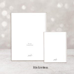 May include: Two white rectangular cards, one larger than the other, are displayed against a soft, blurred background. The larger card has text that reads "Du bist unser Gl&uuml;ck" and the smaller card has the same text. The word "R&uuml;ckseiten" is at the bottom.