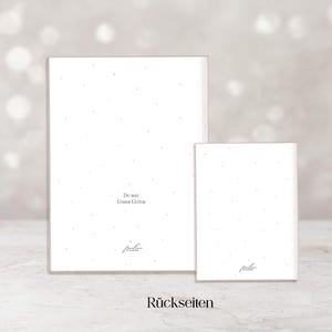 May include: Two white rectangular cards with a speckled pattern and text. The larger card has the text "Du bist Unser Gl&uuml;ck" and the smaller card has the same text. The word "R&uuml;ckseiten" is at the bottom.