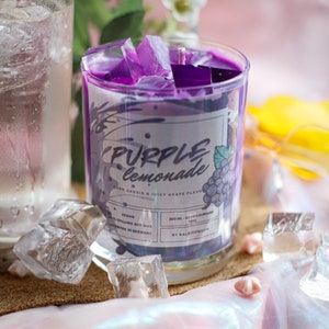 Könnte beinhalten: Lila-Limonade-Duftkerze in einem durchsichtigen Glasgefäß mit lila Wachs und einem Etikett mit der Aufschrift "PURPLE lemonade DARK CASSIS & JUICY GRAPE FLAVOR", "VEGAN", "300 ML. 50HRS BURNING TIME", "BY KALEIDOMECW".