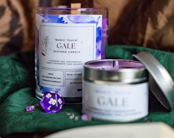 May include: Two purple candles with the text "Magic Touch" Gale Inspired Candle" and "Gale" on the labels. The candles are on a green surface with a purple 20-sided die.