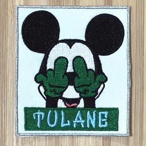 May include: Embroidered patch featuring a cartoon Mickey Mouse with his middle fingers up, covering his eyes. The patch has a green background with the word "TULANE" in blue lettering.