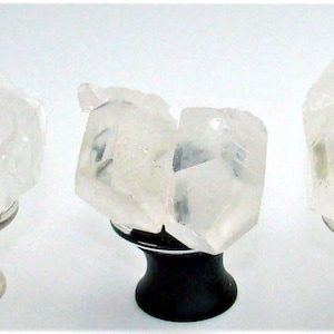 May include: Five clear quartz crystal cabinet knobs with silver, black, and gold-toned bases. The quartz crystals are rough-cut and mounted on decorative hardware. These knobs are ideal for adding a natural, elegant touch to furniture.