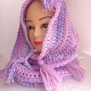 May include: A purple and pink crocheted hooded scarf with tassels. The scarf is made with a soft, textured yarn and has a loose, flowing design.