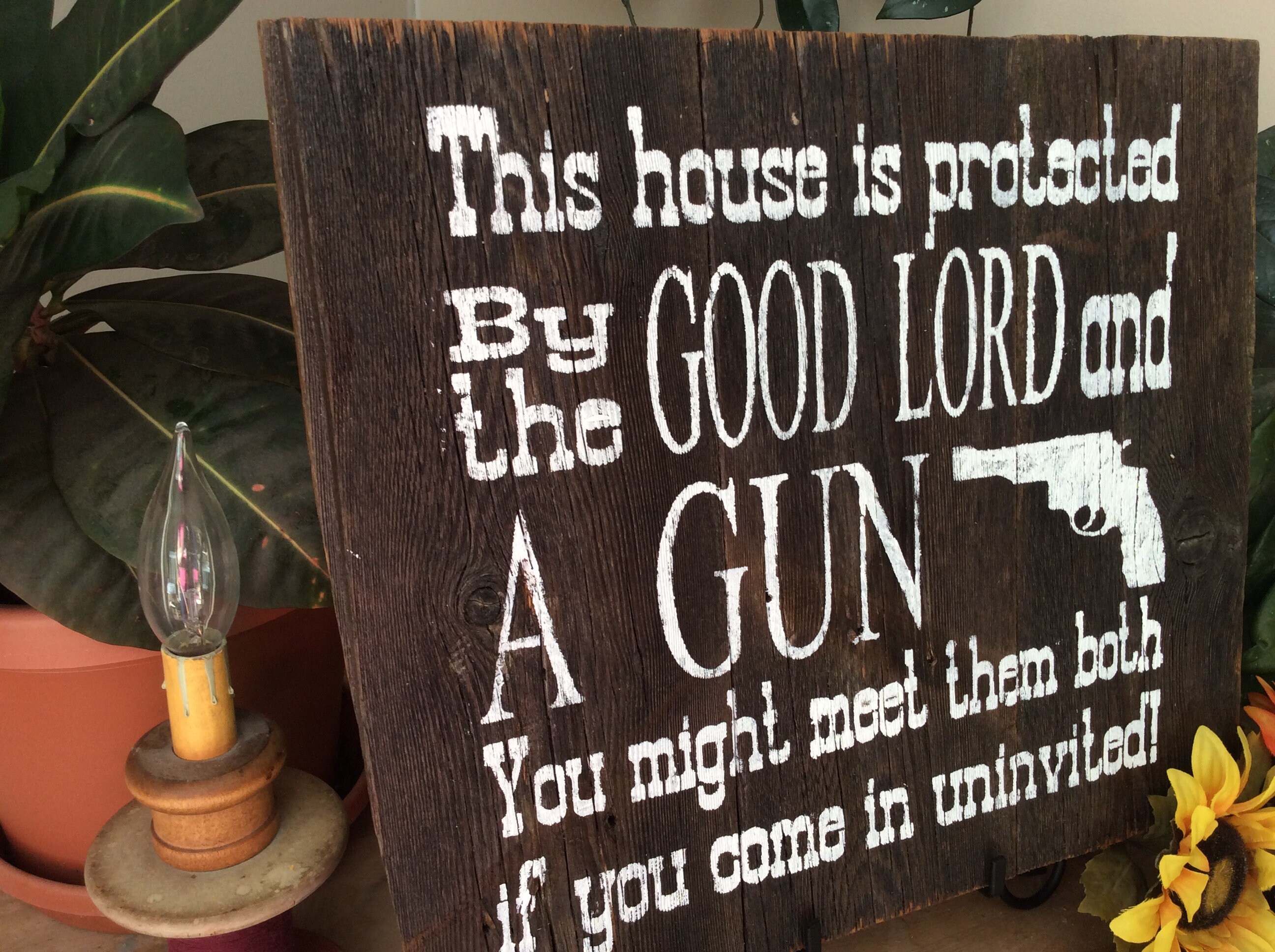western sign this house is protected by good lord and a gun