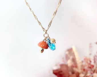 Collier mi-long  "Balade en forêt" champignon orange avec goutte en cristal taillé couleur Aquamarine transmission