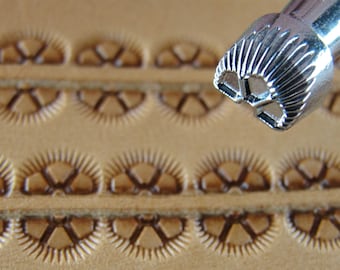 May include: Close-up of a leather stamping tool with a starburst design. The tool is being used to create a pattern on a piece of leather.