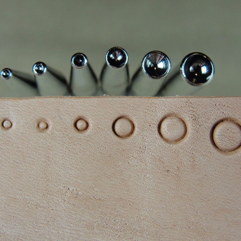 Peut inclure: Un ensemble de huit poin&ccedil;ons en m&eacute;tal pour cuir de diff&eacute;rentes tailles. Les poin&ccedil;ons sont dispos&eacute;s par ordre de taille, le plus petit &agrave; gauche et le plus grand &agrave; droite. Les poin&ccedil;ons sont tous de couleur argent et ont une finition lisse et polie.