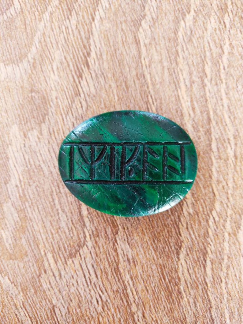 Op de afbeelding: Een groene steen met het woord "TRIPE" erin gegraveerd.