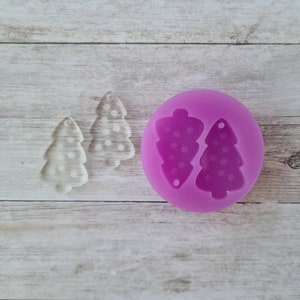 May include: Two clear, tree-shaped resin earrings with white polka dots sit beside a purple silicone mould with matching tree shapes. The earrings have a small hole for hanging. The mould has two tree cavities.