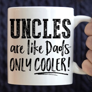 May include: White ceramic mug with the text "UNCLES are like Dads ONLY COOLER!" in black, bold letters. The mug has a curved handle and is held by a person. A perfect gift for an uncle.