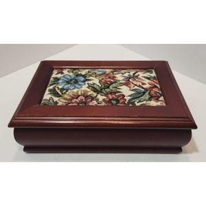 May include: A wooden box with a floral patterned fabric lining. The box is a dark reddish brown color and has a simple design.