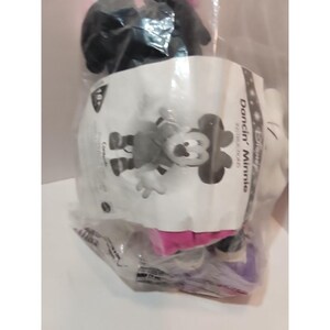 May include: A black and white plush toy of Minnie Mouse in a cheerleader outfit. The toy is packaged in a clear plastic bag with a white label that says "Disney's Dancin' Minnie" and "Soft Touch Plush".