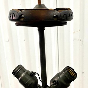 May include: A black metal floor lamp with a wooden base and two light sockets. The base has a carved design.