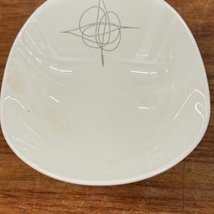 May include: A set of three ceramic mugs with a speckled, matte finish. The mugs are in shades of cream, light gray, and dark gray. Each mug has a simple, minimalist design, perfect for coffee or tea.