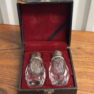 Può includere: Un set di sale e pepe vintage in vetro con tappi argentati, in una scatola foderata in velluto nero.