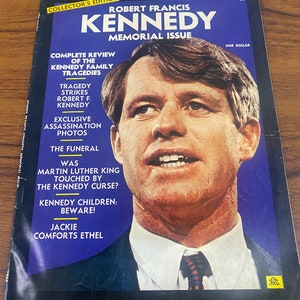 Pode incluir: Uma capa de revista vintage com Robert F. Kennedy. A capa é azul com texto branco e amarelo, incluindo "Collector's Edition" e "Memorial Issue." Os títulos incluem "Complete Review of the Kennedy Family Tragedies" e "Exclusive Assassination Photos."