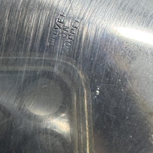 Puede incluir: Primer plano de una fuente de servir de plata con las palabras "SILVER ON COPPER" grabadas en la parte inferior.