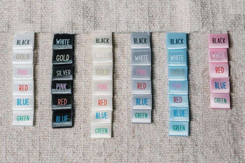 May include: A set of six colour swatches, each with a different colour label. The colours are black, white, gold, pink, red, blue, and green. The swatches are arranged in a row from left to right.