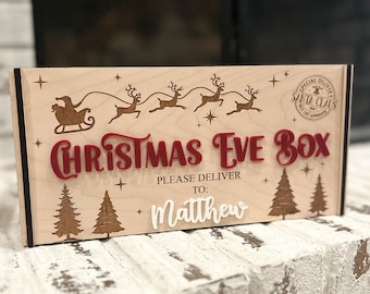 May include: A wooden Christmas Eve box with laser-cut designs. The box features a red "Christmas Eve Box" title, a Santa and reindeer sleigh, and the name "Matthew". Includes a "Special Delivery" stamp.