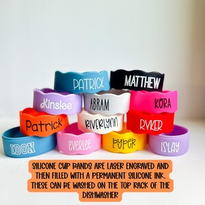 May include: A collection of colourful silicone cup bands featuring laser-engraved names including Patrick, Kinslee, Abram, Riverlynn, Matthew, Kora, Ryker, Idon, Everlee, Pyper, and Islay. The text states these are laser engraved and dishwasher safe.