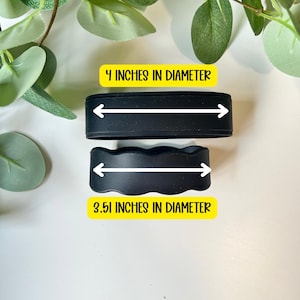 May include: Two black silicone bands. The top band is straight and measures 10.16 cm in diameter. The bottom band has a scalloped edge and measures 8.92 cm in diameter. Both bands feature white arrows indicating the measured diameter.