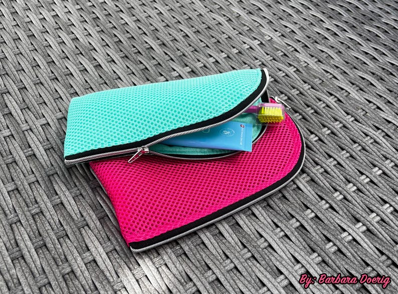 Pu&ograve; includere: Una pochette in rete turchese parzialmente aperta, che rivela un tubetto azzurro e uno spazzolino con setole gialle all'interno, appoggiata sopra una pochette in rete rosa acceso pi&ugrave; grande con bordo nero e cerniera argentata.