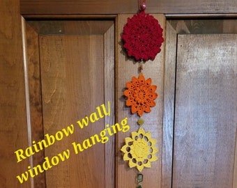 May include: Rainbow wall/window hanging made of crocheted stars in red, orange, yellow, green, blue, and purple.