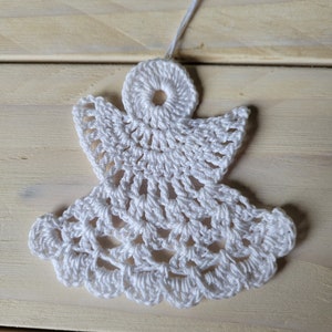 Op de afbeelding: Witte gehaakte engelversiering met een lus om op te hangen.