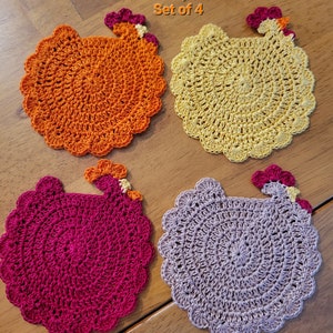 May include: Set of four crocheted chicken-shaped coasters in orange, yellow, red, and taupe.  Orange, Yellow, Red, Taupe Set of 4.