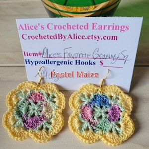 Op de afbeelding: Een paar gehaakte oorbellen in pastelgeel met een veelkleurig granny square-ontwerp. De oorbellen zijn gemaakt met hypoallergene haakjes en zijn gelabeld "Pastel Maize".