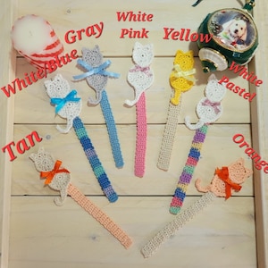 Puede incluir: Un conjunto de 8 marcapáginas de ganchillo con forma de gato, en varios colores, incluyendo blanco, gris, rosa, amarillo, marrón, azul y naranja. Cada marcapáginas presenta un gato de ganchillo con un lazo.