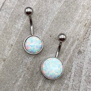 May include: Two silver belly button rings with opal-like stones. The stones are a light blue color with white and pink flecks.