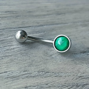 May include: A silver belly button ring with a green malachite stone.