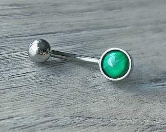 May include: A silver belly button ring with a green malachite stone.