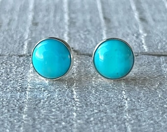 May include: A pair of silver stud earrings with round turquoise stones.
