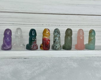 May include: Eight small, carved, polished stone figures in various colors, including purple, clear, green, red, grey, green, pink, and light blue.
