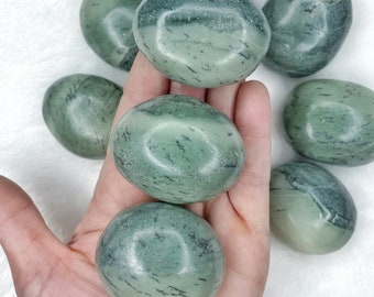 May include: A collection of seven smooth, green and black tumbled stones. The stones have a marbled appearance with dark green and black streaks.