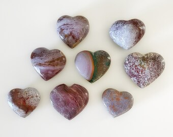 May include: Eight heart-shaped polished stones with various patterns of red, brown, white, and green.
