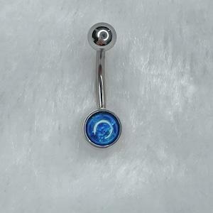 May include: A silver belly button ring with a blue and white crescent moon design.