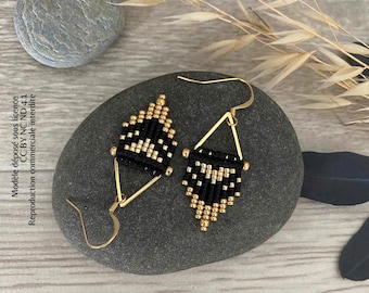 May include: A pair of black and gold geometric earrings with a triangle shape. The earrings are made with small beads and have a gold hook.