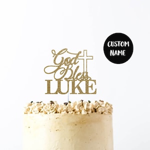 May include: Gold glitter cake topper with the text "God Bless LUKE" and a cross. The topper is on a white cake with brown frosting. The cake is on a black cake stand. The text "CUSTOM NAME" is in a circle on the right side of the image.