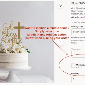 Pu&ograve; includere: Un topper per torta color oro con la scritta God Bless e il nome SOPHIE in carattere corsivo e stampatello, accompagnato da un simbolo a croce. Il topper &egrave; posizionato su una torta glassata bianca decorata con fiori bianchi su un'alzata.