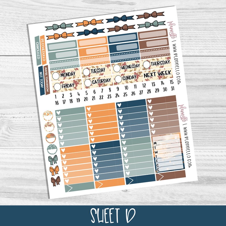 May include: A sheet of planner stickers with an autumn theme. The stickers feature various designs, including bows, hearts, leaves, and a calendar grid. The colours are orange, brown, blue, and white.