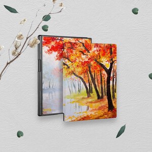 May include: Two hardcover journals with a painting of an autumn forest scene. The painting features a lake with reflections of the trees and a path leading into the woods. The trees are a mix of orange, red, and yellow.