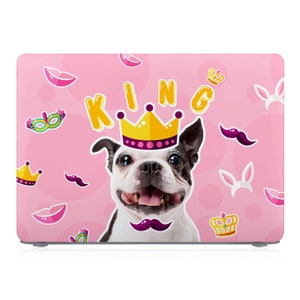 Könnte beinhalten: Rosa Laptop-Haut mit einem Cartoon-Hund, der eine Krone trägt und dem Wort "KING" in gelben Buchstaben. Der Hintergrund hat ein rosa-weißes Punkte-Muster mit anderen Cartoon-Bildern.