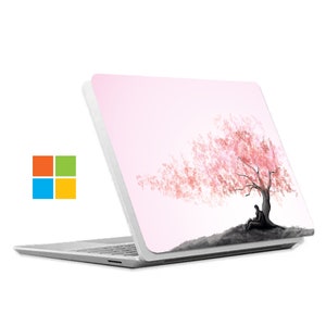 May include: A white laptop with a pink and white design featuring a stylized silhouette of a person sitting under a blooming cherry blossom tree.