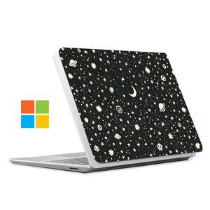 May include: A white laptop with a black and white starry night design on the lid. The design features stars, moons, and planets.